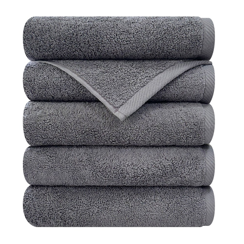 Songwol Crush hotel towels in dark gray, stacked five high with one corner unfolded to show the woven border