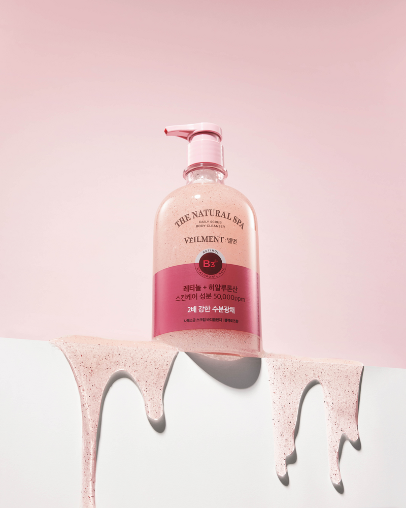 Veilment Black Rose scrub body wash on a white ledge, with pink grainy gel draped over the edge