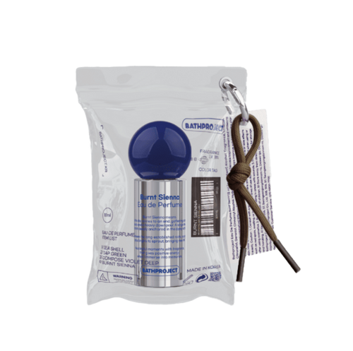 Bath Project eau de parfum silver bottle with a blue round cap inside a clear pouch beside a cord keyring