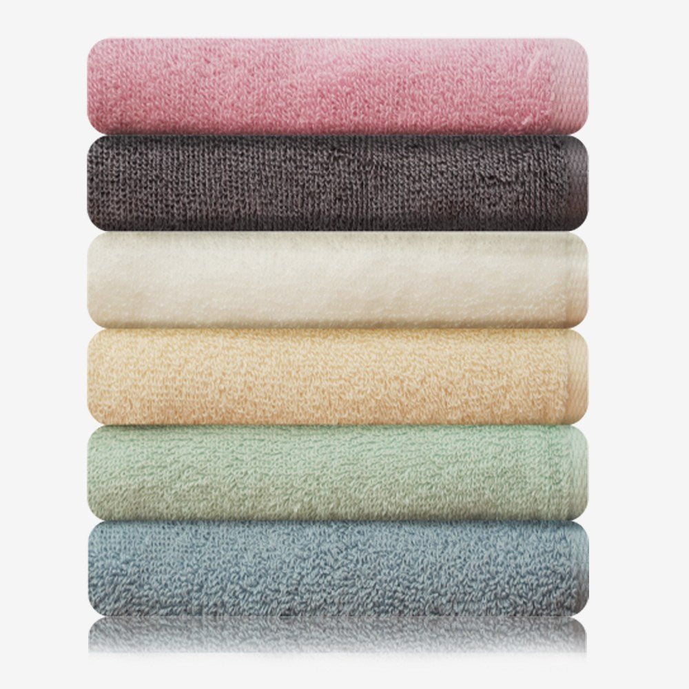 Songwol Simple Color face towels range stacked in pink, dark gray, cream, yellow, mint and blue on white