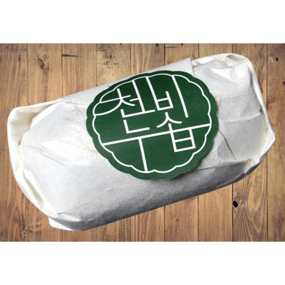 Cheonbinusop Jeongango soap bar wrapped in white paper with a round dark green Korean label on a wooden surface