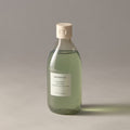 Aromatica Awakening body wash in a clear 300ml bottle with pale green liquid and a cream cap on a grey surface