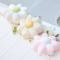 Round Around Flower Bath Bomb designs in white, cream and pink, arranged with small flowers on a tiled bath edge