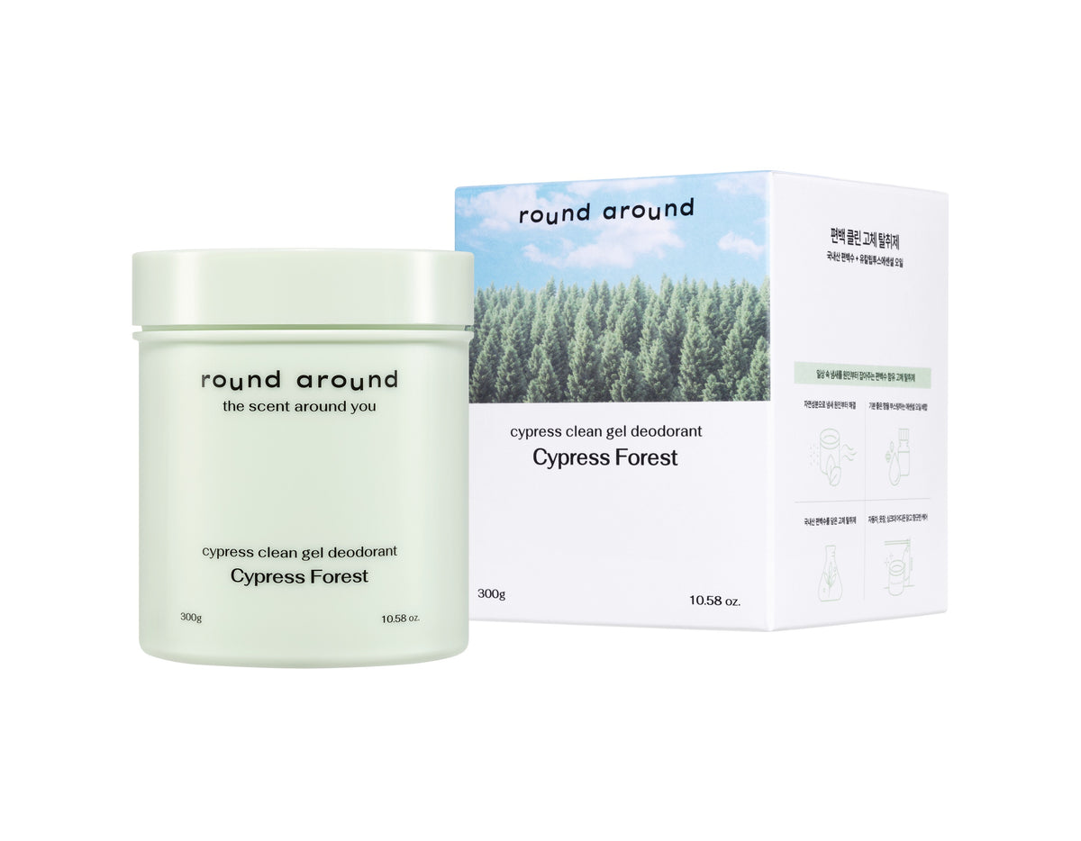 Round Around air freshener in a pale green Cypress Forest jar beside a white box with a forest photograph