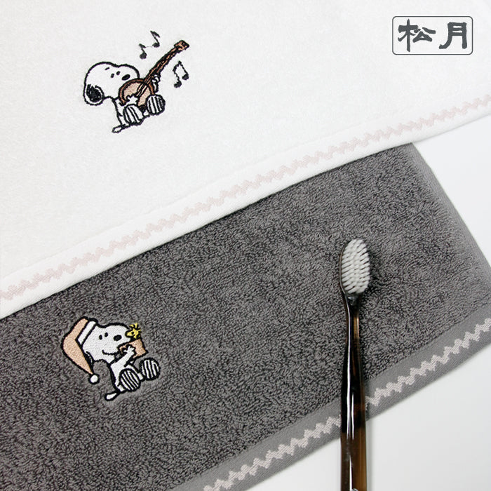 Songwol Snoopy solid face towels close up in ivory and gray, showing character details, textured fabric and a toothbrush