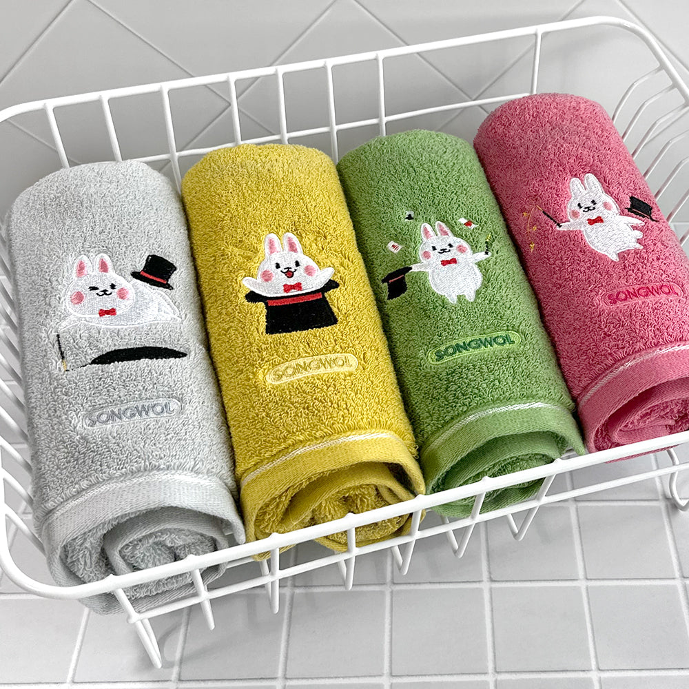 Songwol rabbit face towel set range showing grey, yellow, green and pink embroidered towels in a wire basket