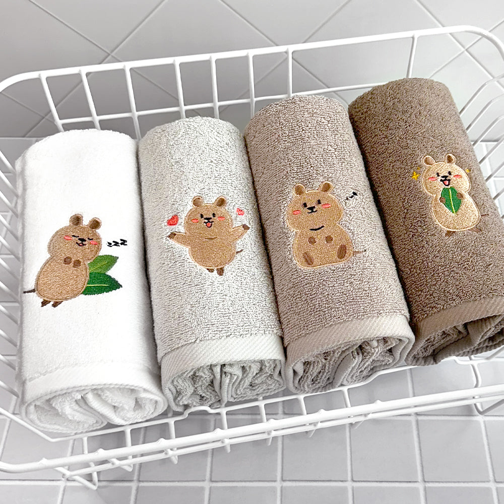 Songwol Quokka face towels rolled in a white wire basket, with hearts, leaves and musical embroidery details