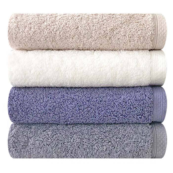 Songwol combed cotton bath towels in a close stack showing terry loops and woven borders in four colours