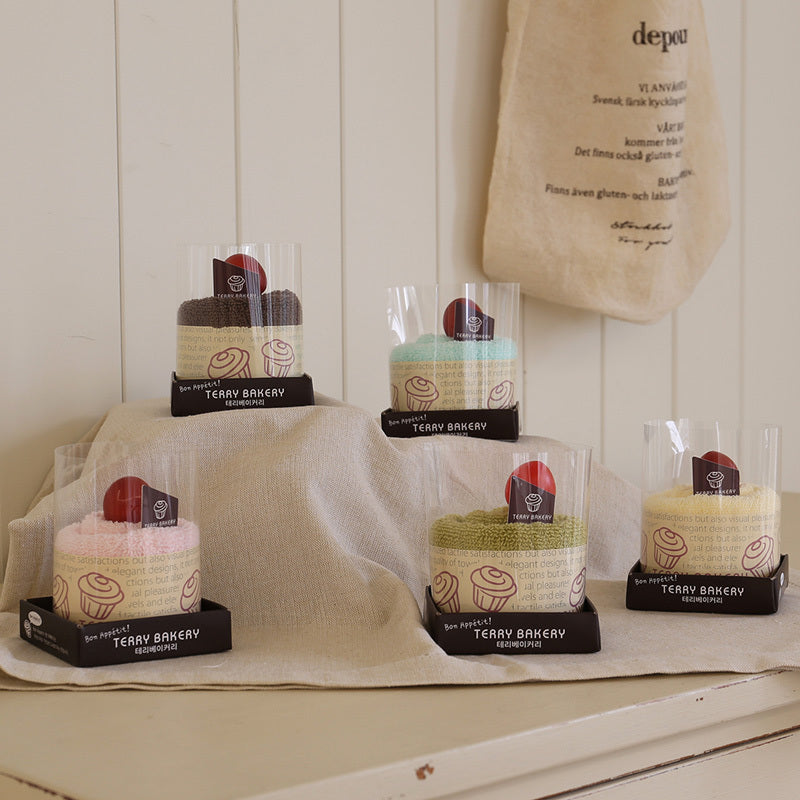 Songwol Mini mousse cake towels in five colours, displayed in clear cake packaging on a draped cream cloth