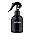 Bath Project Forest Blue body spray in a glossy black bottle with a curved trigger dispenser on white