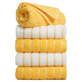 Towel Talk Seacline face towels stacked in yellow and white striped designs, with a loose fold on top