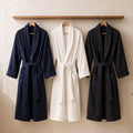 Songwol Jin Gray bath robe hanging beside navy and white robes, with waist belts, shawl collars and front pockets