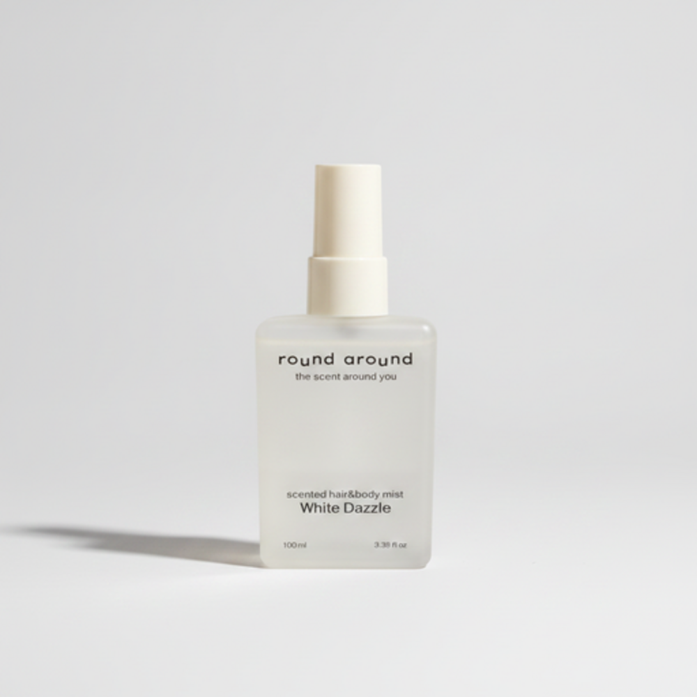 Round Around White Dazzle hair body mist in a frosted rectangular bottle with a cream spray top and long shadow
